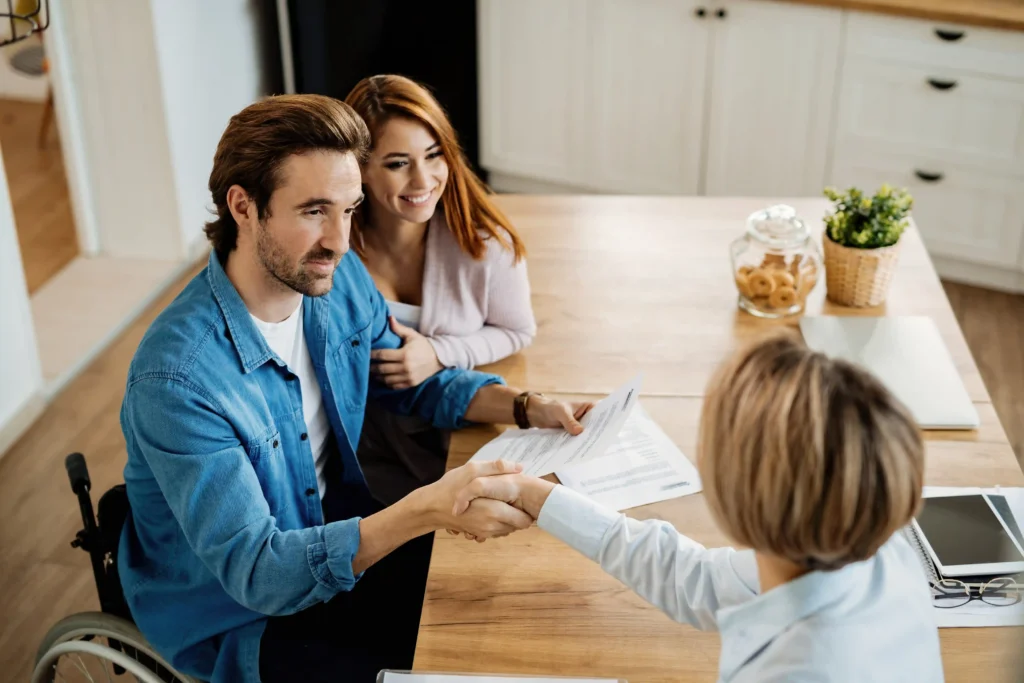 young-happy-couple-making-agreement-with-their-insurance-agent-meeting-home-focus-is-man-wheelchair